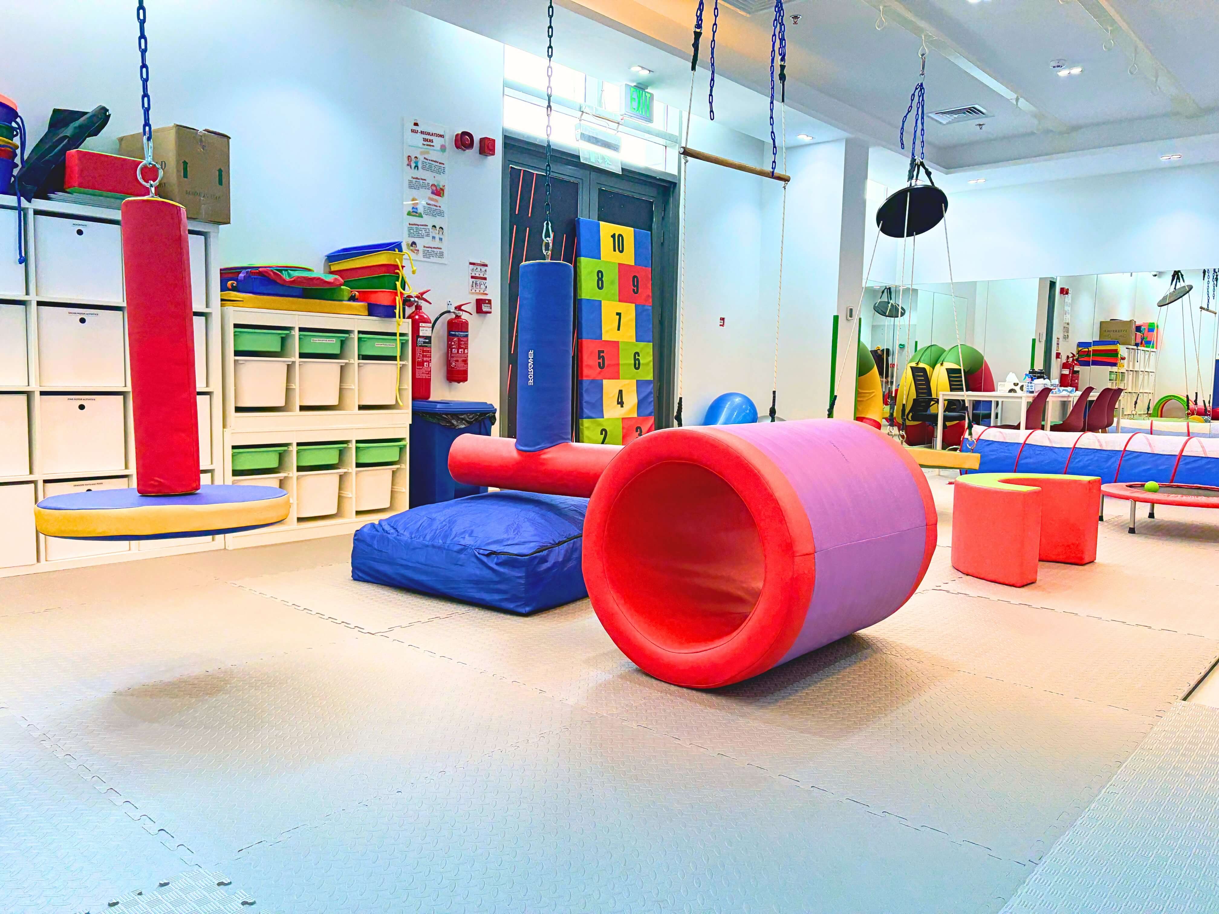 Dedicated sensory integration room at Bridges Care Speech Therapy Center with swings, climbing wall, soft-play equipment and graded sensory tools